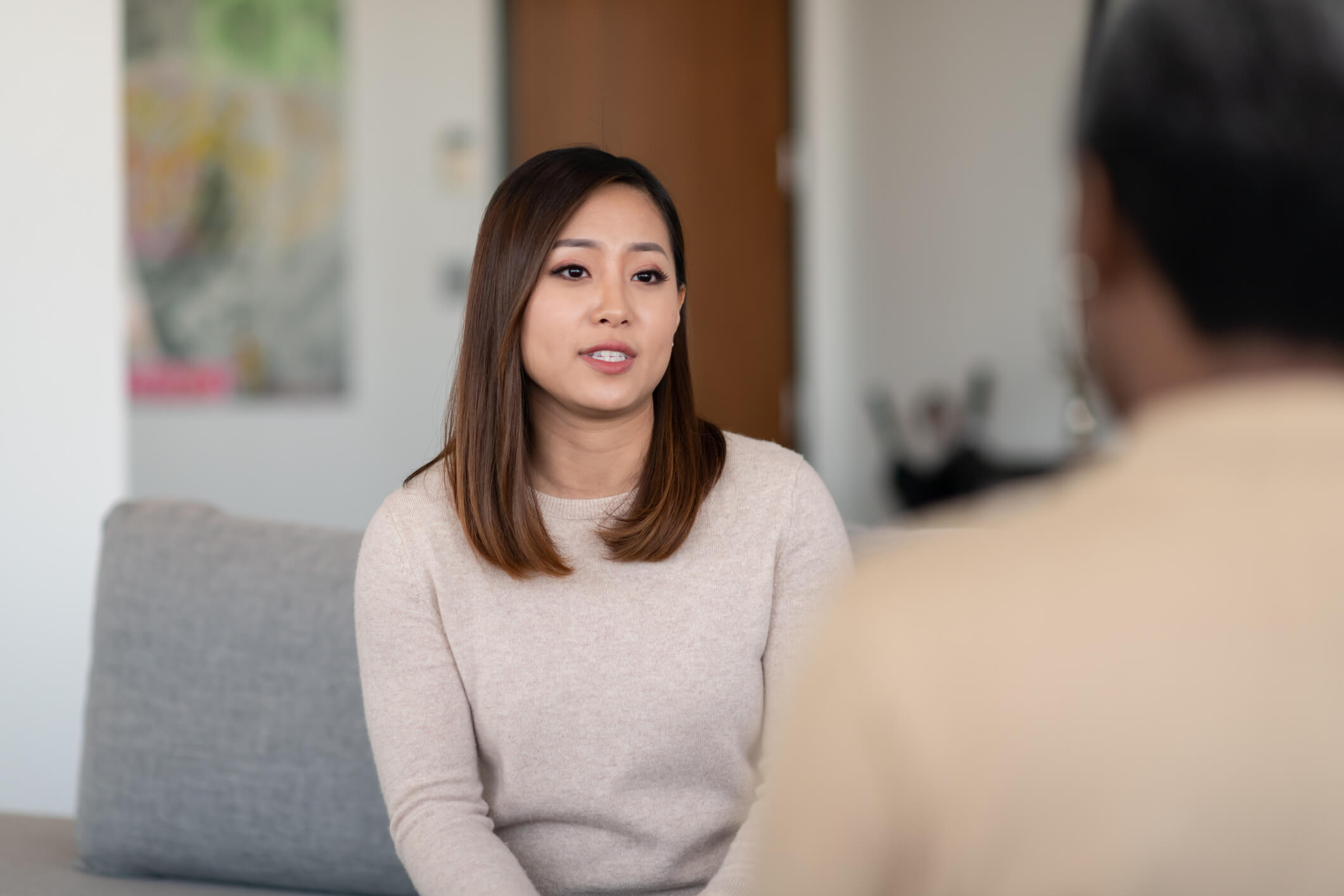 An Asian woman talks to a therapist about her marriage. She is serious about working on her relationship with her husband, but she is frustrated.