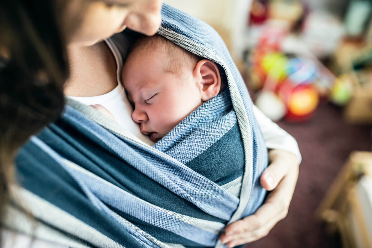 Young baby swaddled against mother's chest